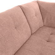 Nahaufnahme einer rosafarbenen Rundecke mit weichem Stoffbezug und gepolsterten Kissen, Blick auf die Ecke des Sofas.