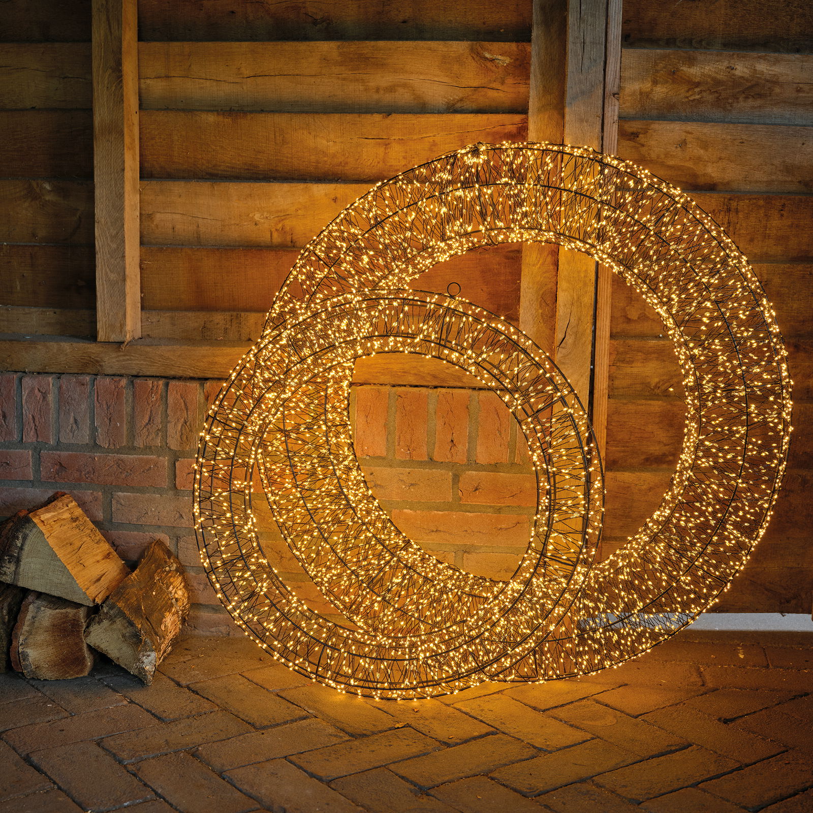 Zwei leuchtende LED-Kränze in einer rustikalen Umgebung, frontal betrachtet.