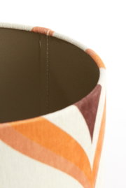 Close-up van een lampenkap met een geometrisch patroon in oranje- en bruintinten, gezien vanuit de zijkant.