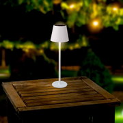 Zonne-tafellamp op een houten tafel buiten, 's nachts gefotografeerd
