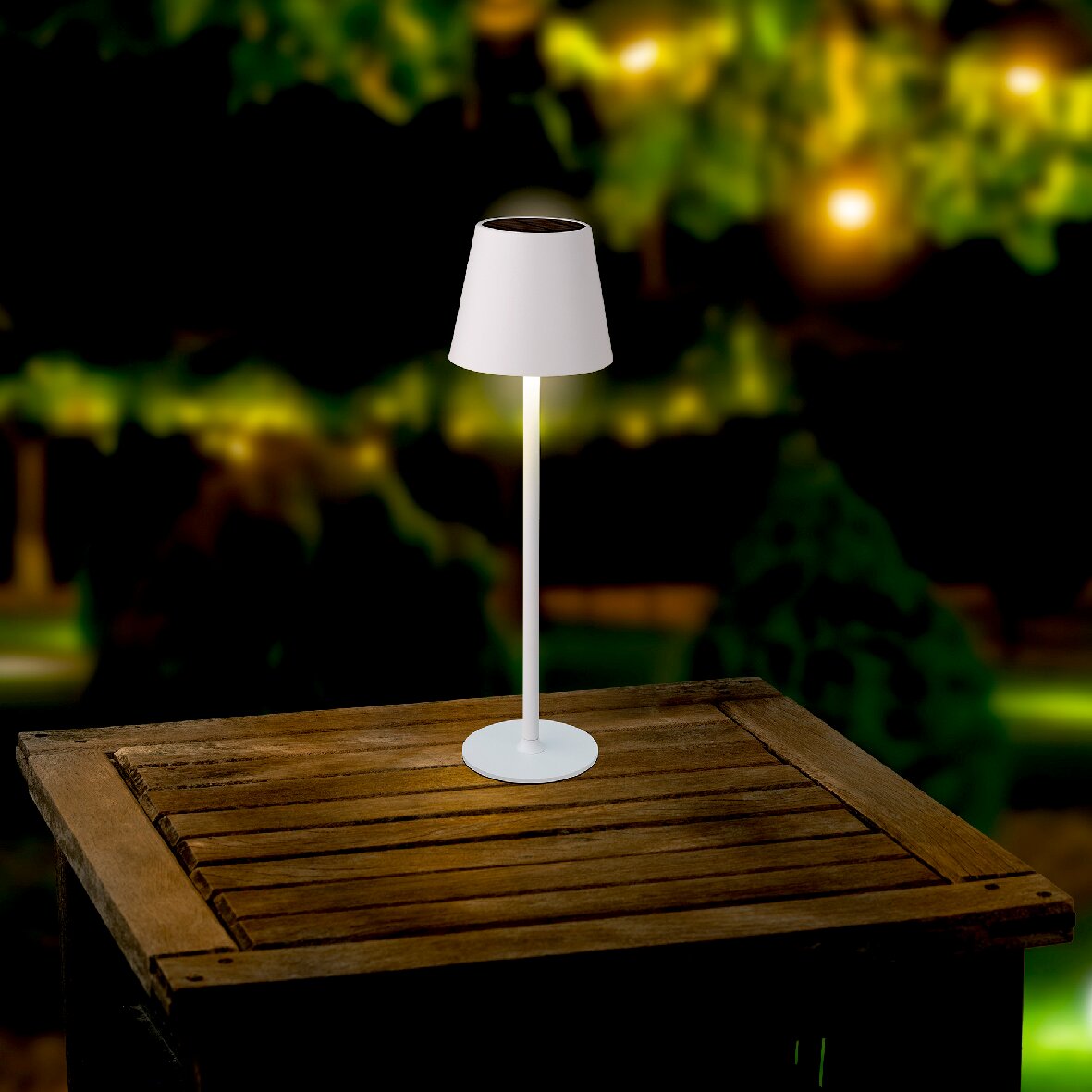 Zonne-tafellamp op een houten tafel buiten, 's nachts gefotografeerd