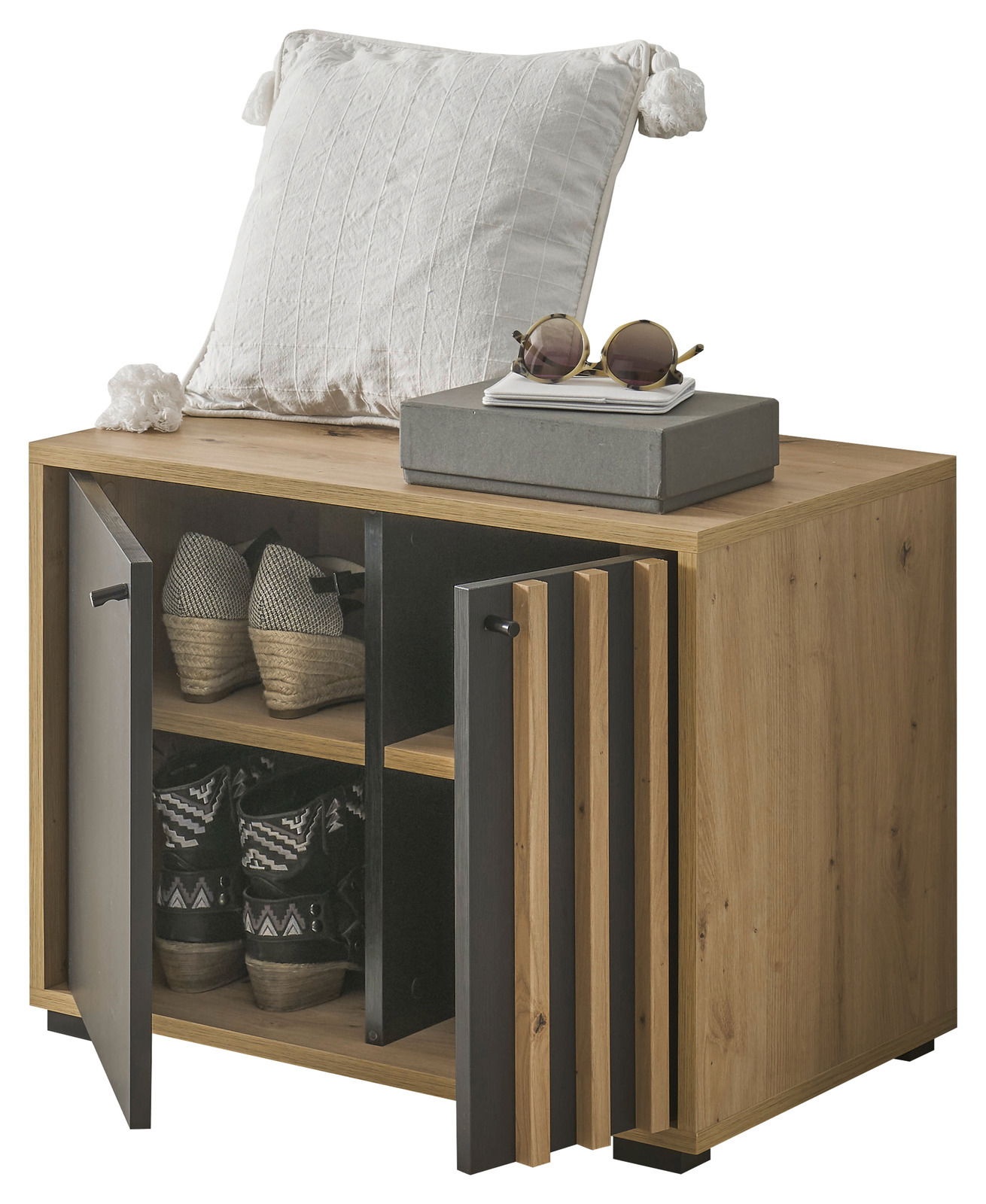 Garderobenbank aus Holz mit zwei offenen Türen, die Schuhe auf zwei Ebenen zeigen. Obenauf liegt ein weißes Kissen und eine Sonnenbrille. Perspektive von vorne links.