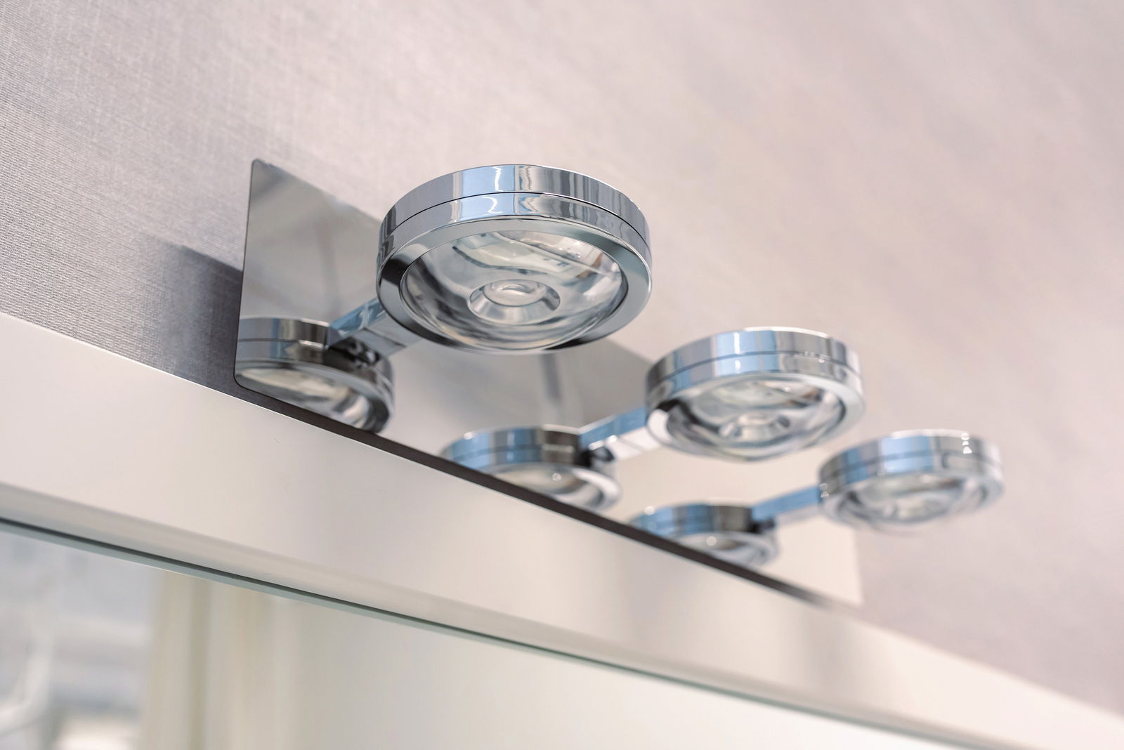 Moderne LED Wandleuchte mit vier runden, verchromten Leuchten, von unten fotografiert.