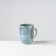 Blau glasierte Keramik-Kaffeetasse mit Henkel auf weißem Hintergrund, Produktansicht leicht von vorne/rechts in Augenhöhe