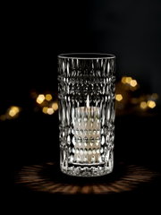 Kristallklare Vase oder Windlicht mit strukturiertem Muster, beleuchtet von einer Kerze, auf dunklem Hintergrund, frontal betrachtet.