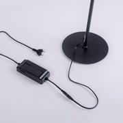 Nahaufnahme der Basis einer schwarzen Stehleuchte CURLS mit Stromkabel und Stecker.