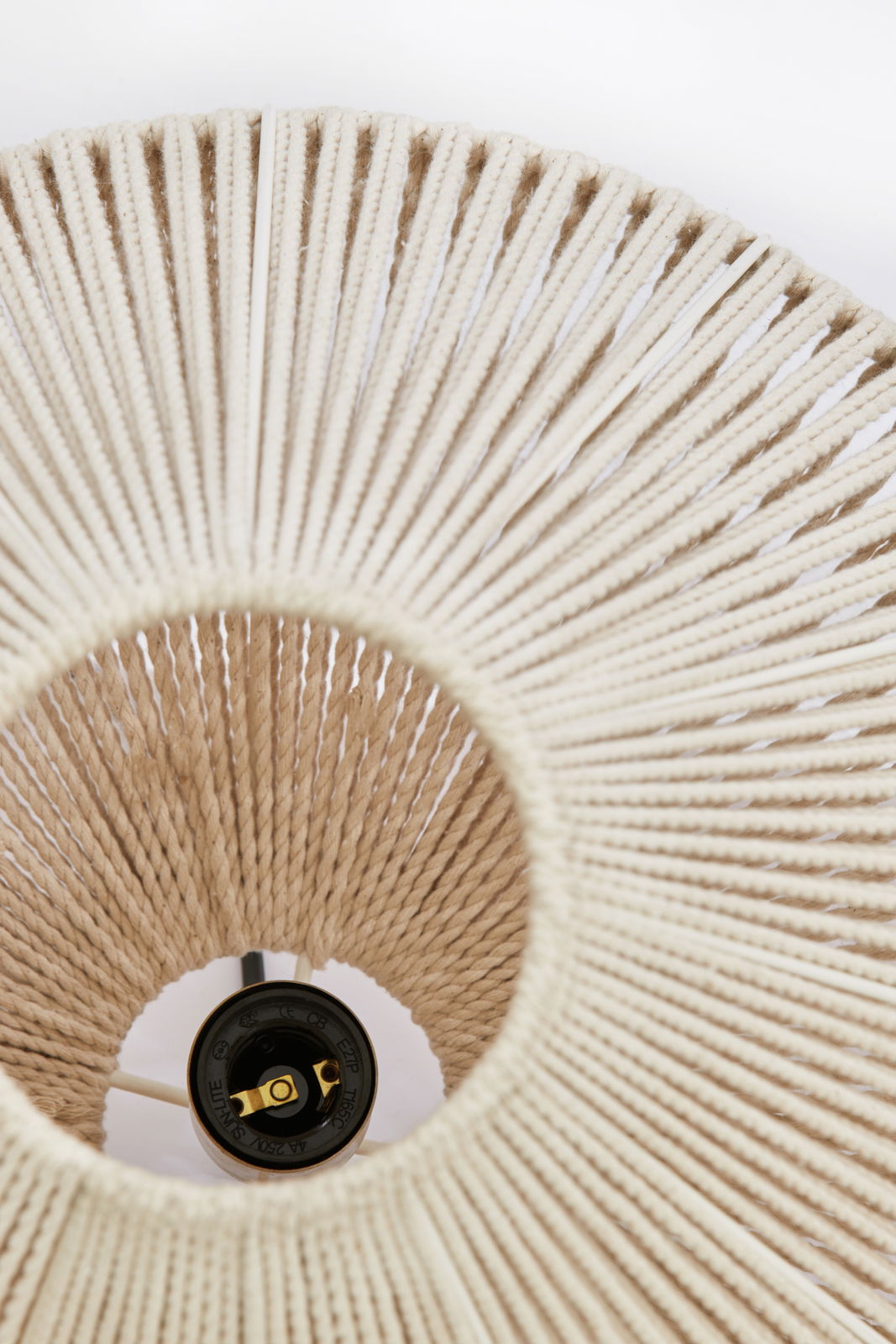 Nahaufnahme einer Hängeleuchte aus geflochtenem Material, von unten betrachtet.