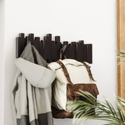 Moderne Wandgarderobe mit geometrischem Design, von der Seite betrachtet, mit aufgehängtem Mantel und Rucksack.
