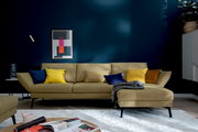 Moderne Longchairkombination in senfgelber Farbe mit bunten Kissen, frontal fotografiert in einem stilvoll eingerichteten Wohnzimmer.