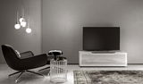 Modernes Wohnzimmer mit TV-Lowboard in Weiß, frontal betrachtet, neben einem schwarzen Sessel und einem Beistelltisch.