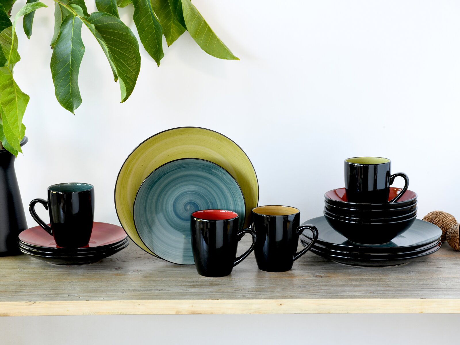 creaTable Kombiservice 16-tlg SAMBA Kombiservice 16-tlg in verschiedenen Farben, bestehend aus Tassen, Tellern und Schalen, auf einem Holzregal ausgestellt. Frontalansicht.