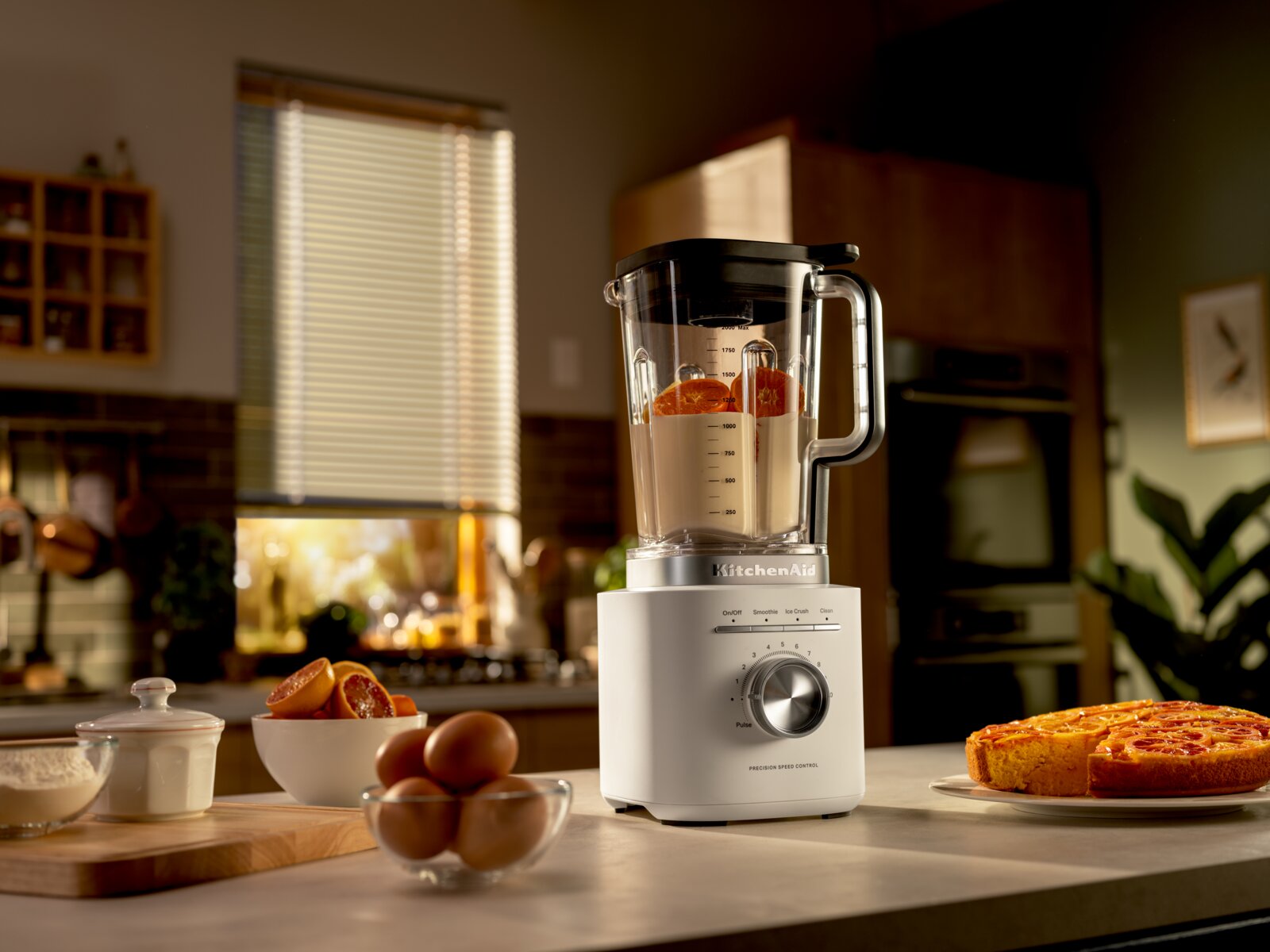 KitchenAid Standmixer 2,1 L PORCELAIN WHI PURE POWER BLENDER Standmixer in einer modernen Küche, gefüllt mit Zutaten, seitliche Perspektive