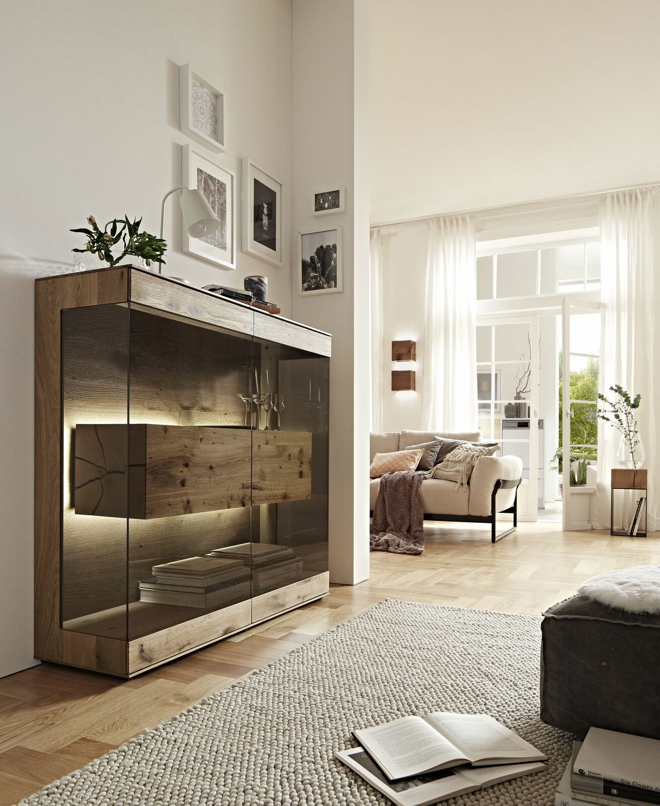 Modernes Highboard aus Holz mit Glastüren, beleuchtet, in einem stilvollen Wohnzimmer, seitliche Perspektive