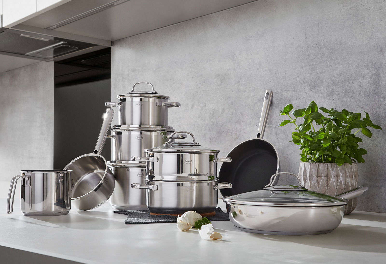 Elegantes 10-teiliges Topfset aus Edelstahl in moderner Küchenumgebung, seitliche Perspektive.