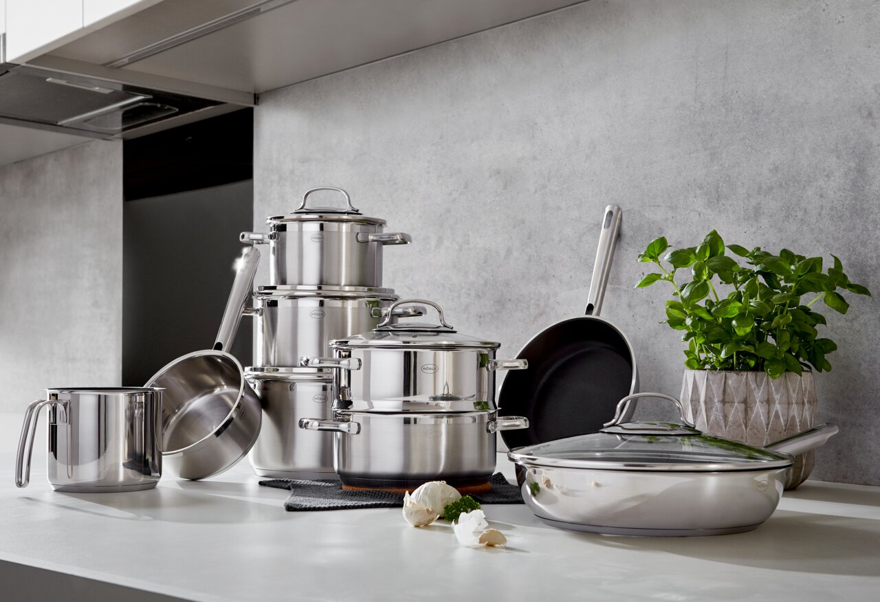 Elegante 10-delige pannenset van roestvrij staal in een moderne keuken, zijaanzicht.