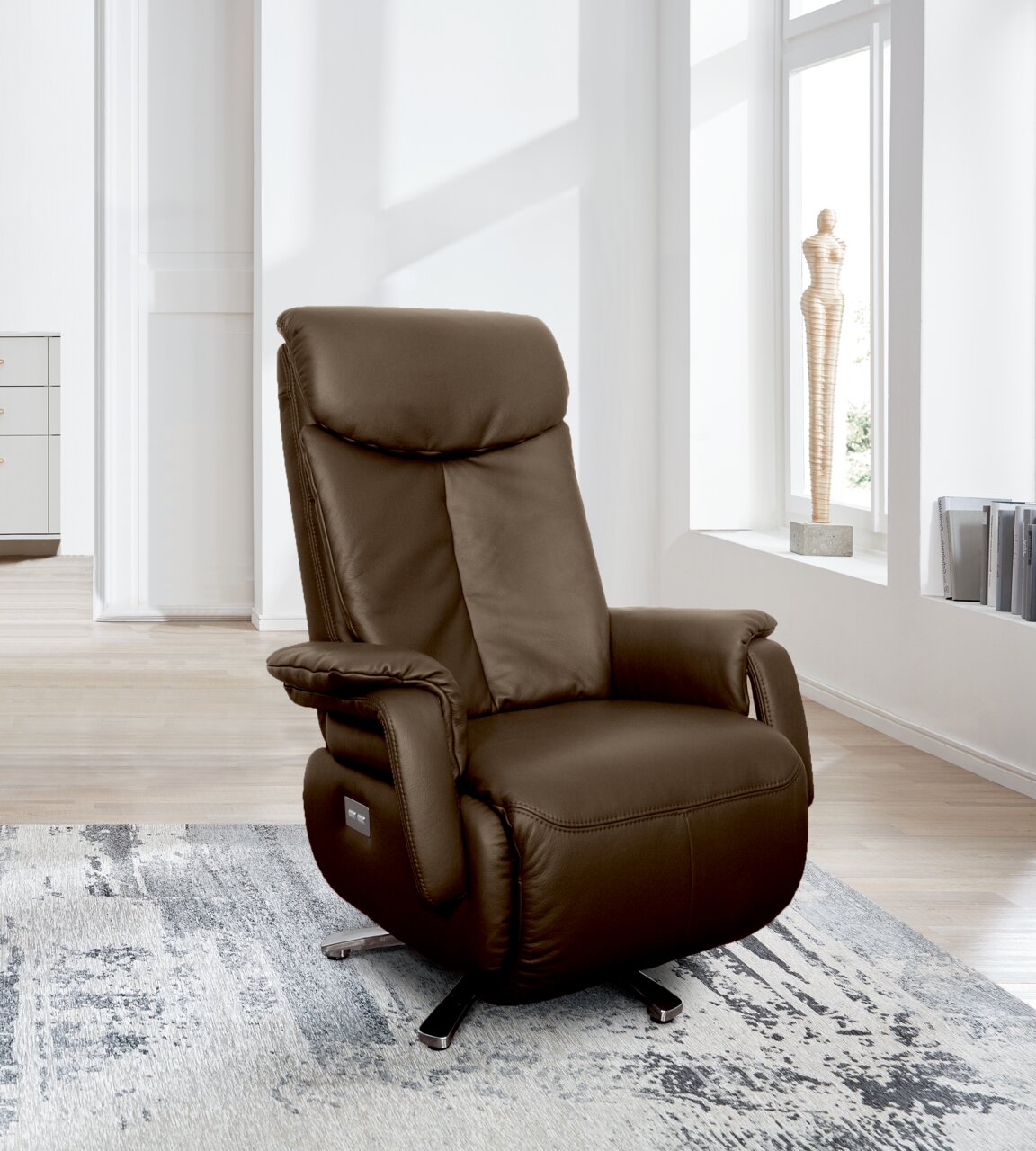 Bruine leren tv-fauteuil in een moderne woonkamer, gezien vanaf de zijkant.