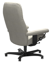 Rückansicht eines grauen Chefsessels mit Armlehnen und schwarzem Drehfuß auf Rollen.