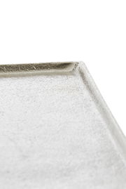 Nahaufnahme einer weißen, strukturierten Schale mit leicht erhöhtem Rand, aus seitlicher Perspektive fotografiert.