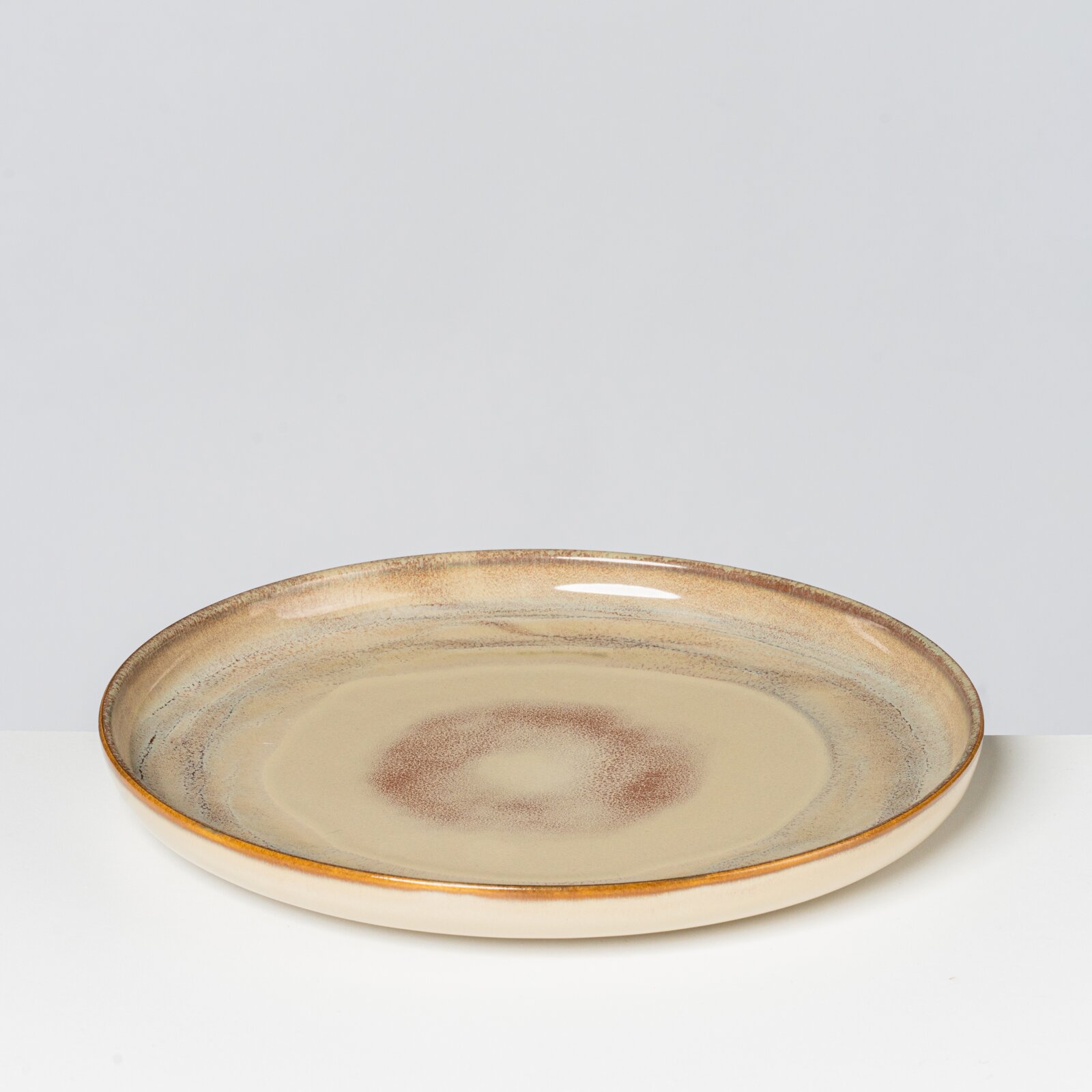 Runder Keramik-Essteller in Beige mit braunem Sprenkel- und Ringdekor sowie braunem Rand, frontal aus leicht erhöhter Perspektive fotografiert.