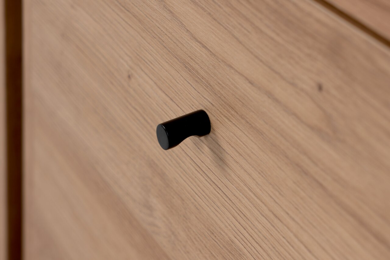 Nahaufnahme eines schwarzen Griffs auf einer Holzoberfläche, seitliche Perspektive