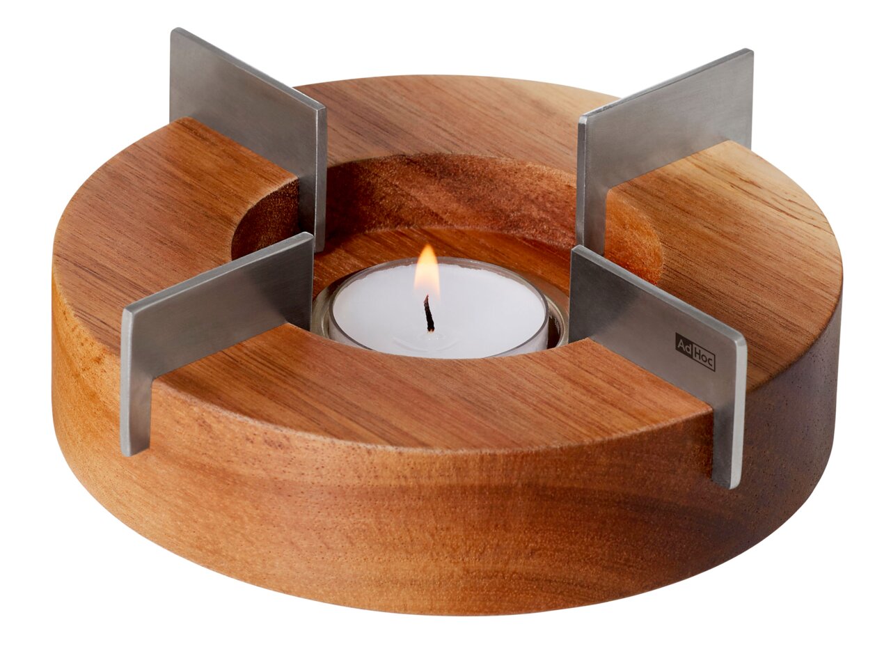 Rundes Stövchen aus Holz mit vier Metallhaltern und einem brennenden Teelicht in der Mitte, seitliche Perspektive.