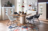 Esszimmer mit modernem Esstisch und Stühlen, umgeben von stilvollen Vitrinen und Sideboards, Perspektive von vorne.