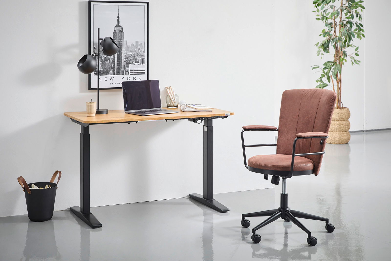 Moderner höhenverstellbarer E-Schreibtisch mit Holzplatte und schwarzem Gestell, seitliche Perspektive, mit Laptop und Schreibtischlampe dekoriert.