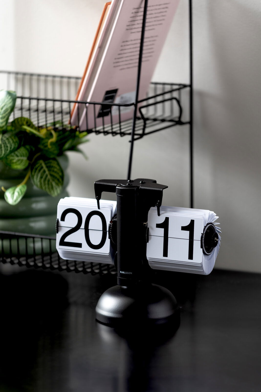 Retro Tischuhr mit Klappzahlen auf einem Tisch, seitliche Perspektive