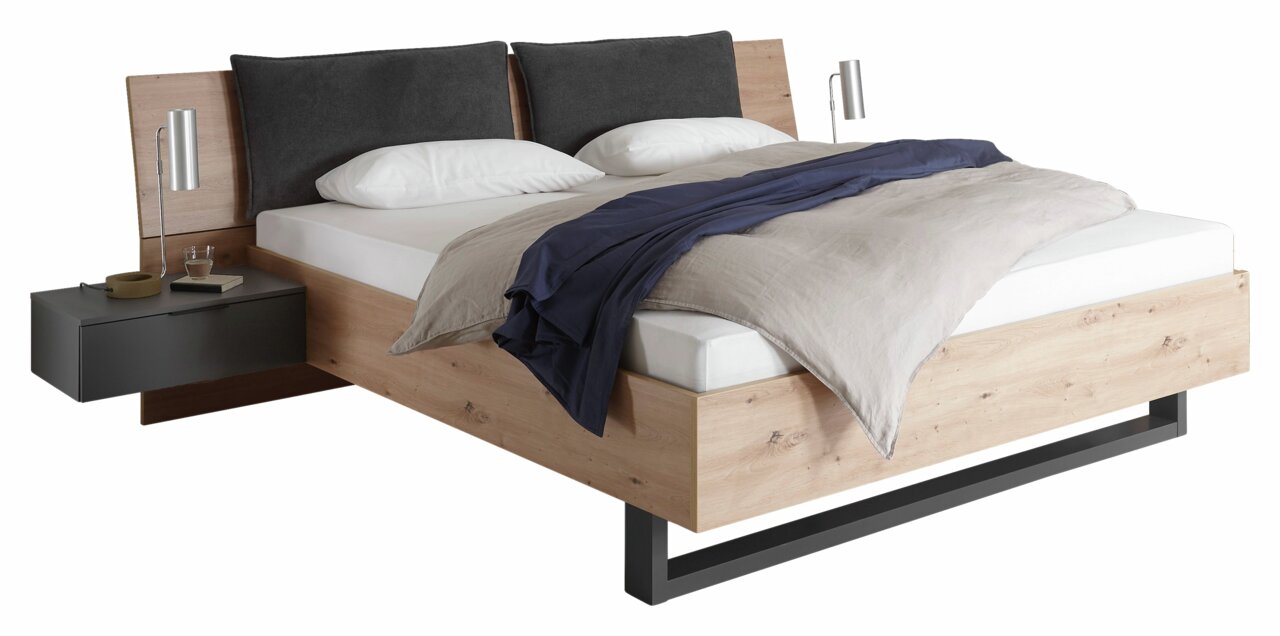 Modernes Bett mit Holzrahmen, grauen Kopfkissen und integrierten Nachttischen, seitliche Perspektive