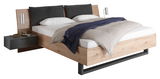 Modernes Bett mit Holzrahmen, grauen Kopfkissen und integrierten Nachttischen, seitliche Perspektive