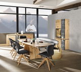 Moderne Esszimmergarnitur mit Esstisch, Stühlen und Bank aus Holz in einem hellen Raum mit Bergblick, seitliche Perspektive.