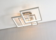 Moderne led-plafondlamp met overlappende vierkante randen in metaallook, met een warmwitte lichtkleur, gefotografeerd vanaf de onderkant van het plafond.