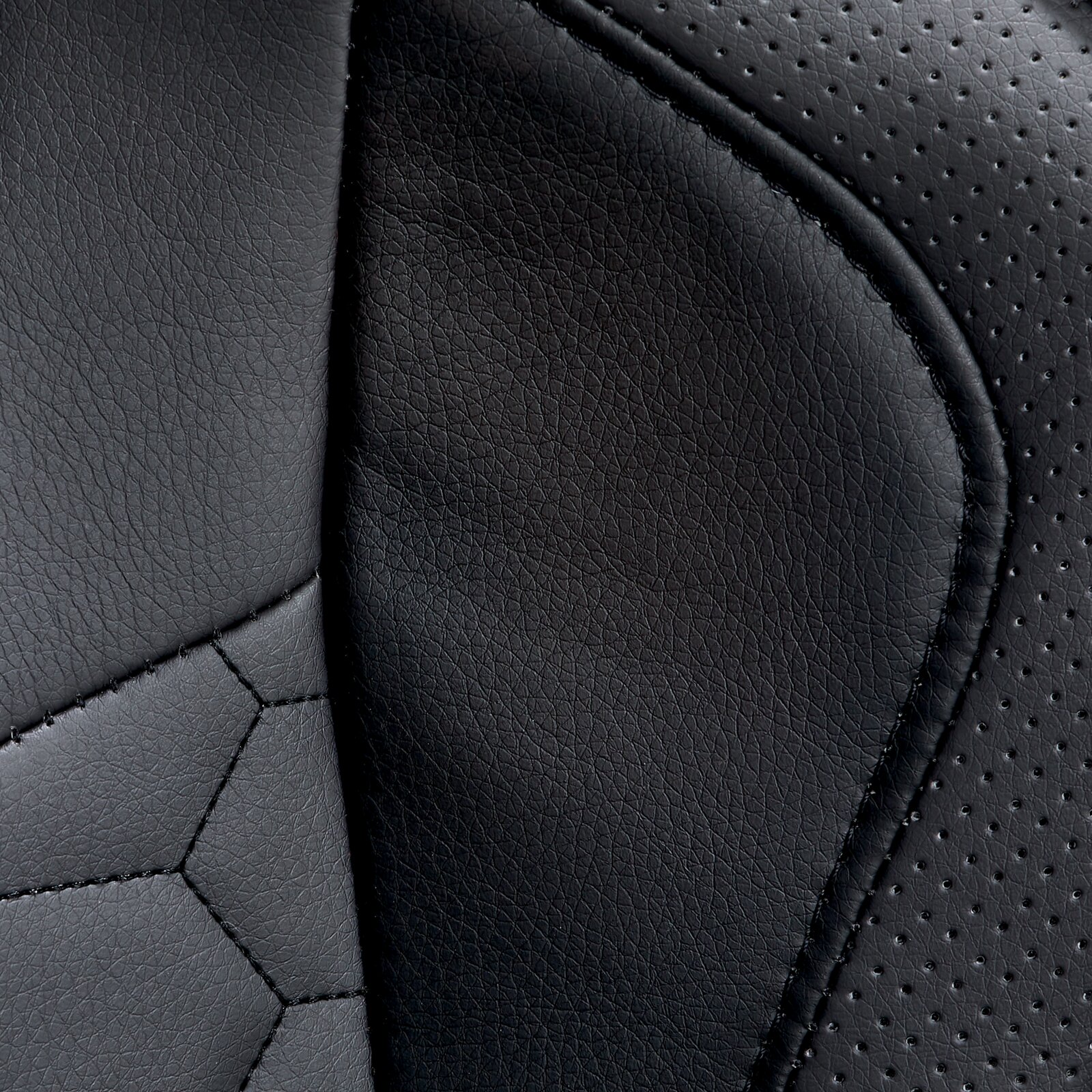 Close-up van de zwarte lederen bekleding van een gamingstoel met geperforeerde en gladde delen.