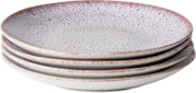 Stapel aus vier flachen Keramik-Esstellern in Creme mit gesprenkelter Glasur und braunem Rand, schräg von oben in leichter Seitenansicht fotografiert