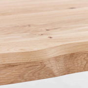 Nahaufnahme einer Tischkante aus hellem Holz mit natürlicher Maserung, seitliche Perspektive
