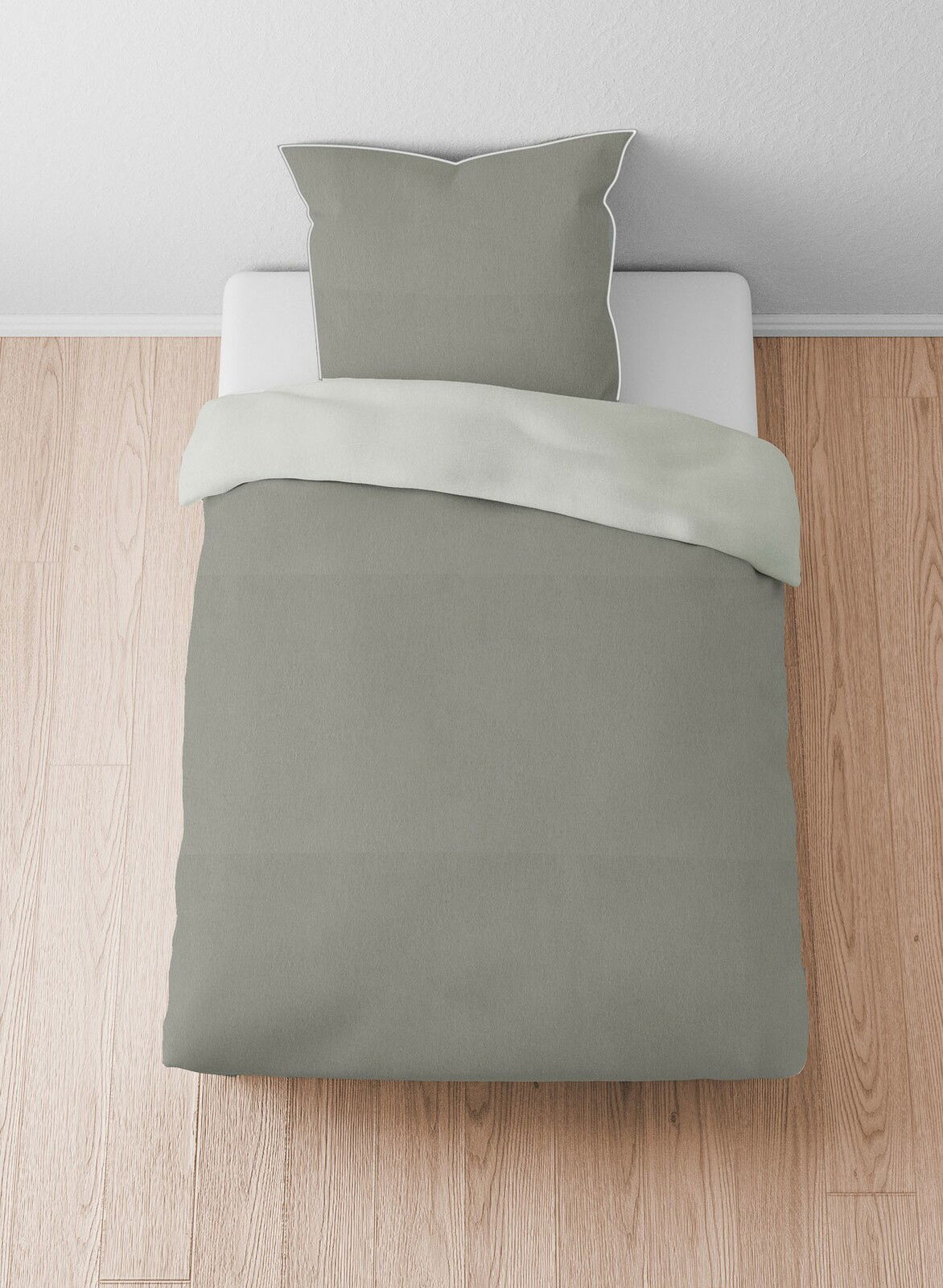 Bettwäsche-Set aus Melange-Flanell in Grau, bestehend aus einem Kissenbezug und einem Bettdeckenbezug, auf einem Bett von oben fotografiert.