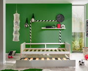 Jugendbett mit ausziehbarem Bettkasten, umgeben von sportlichen Dekorationen in einem grünen Zimmer, seitliche Perspektive