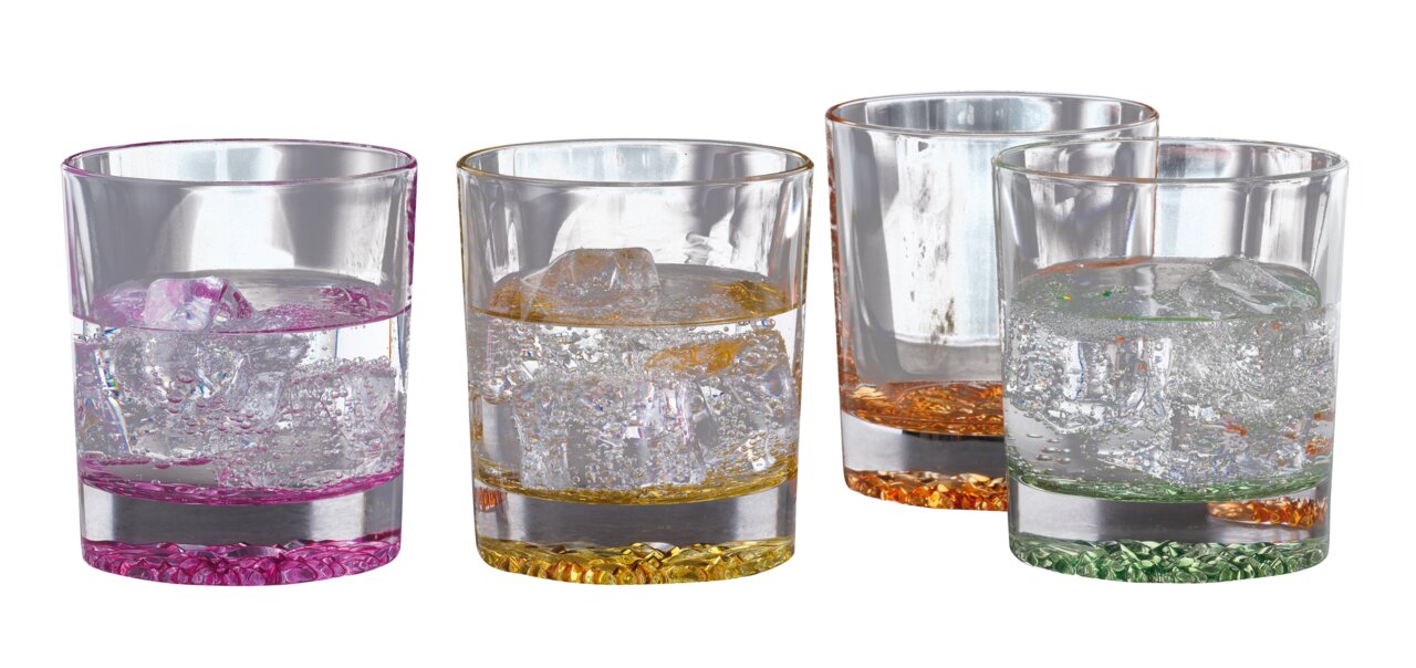 Vier bunte Trinkbecher mit Eiswürfeln und sprudelndem Wasser, aus der Vorderansicht fotografiert.