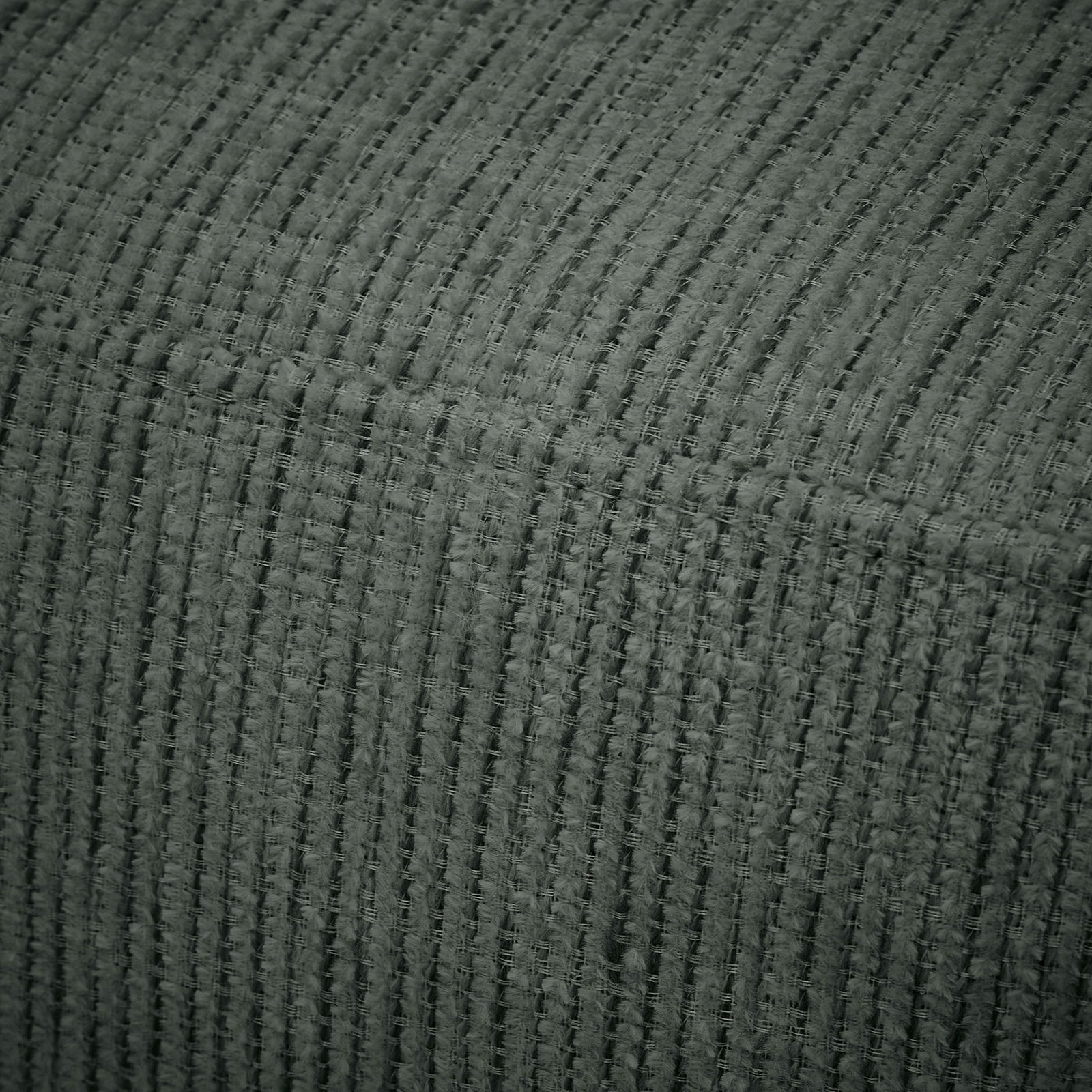 Nahaufnahme eines strukturierten, gerippten Stoffes in dunklem Grau, perspektivisch von der Seite aufgenommen.