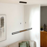 Moderne LED-Hängeleuchte in minimalistischem Design, von der Decke hängend über einem Sofa, seitliche Perspektive.
