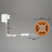 Weißes Netzteil mit Eurostecker, Kabel und Inline-Schalter neben aufgerolltem LED-Lichtband auf Pappspule, Längenangaben 1500 mm/500 mm/3000 mm, Draufsicht auf grauem Hintergrund