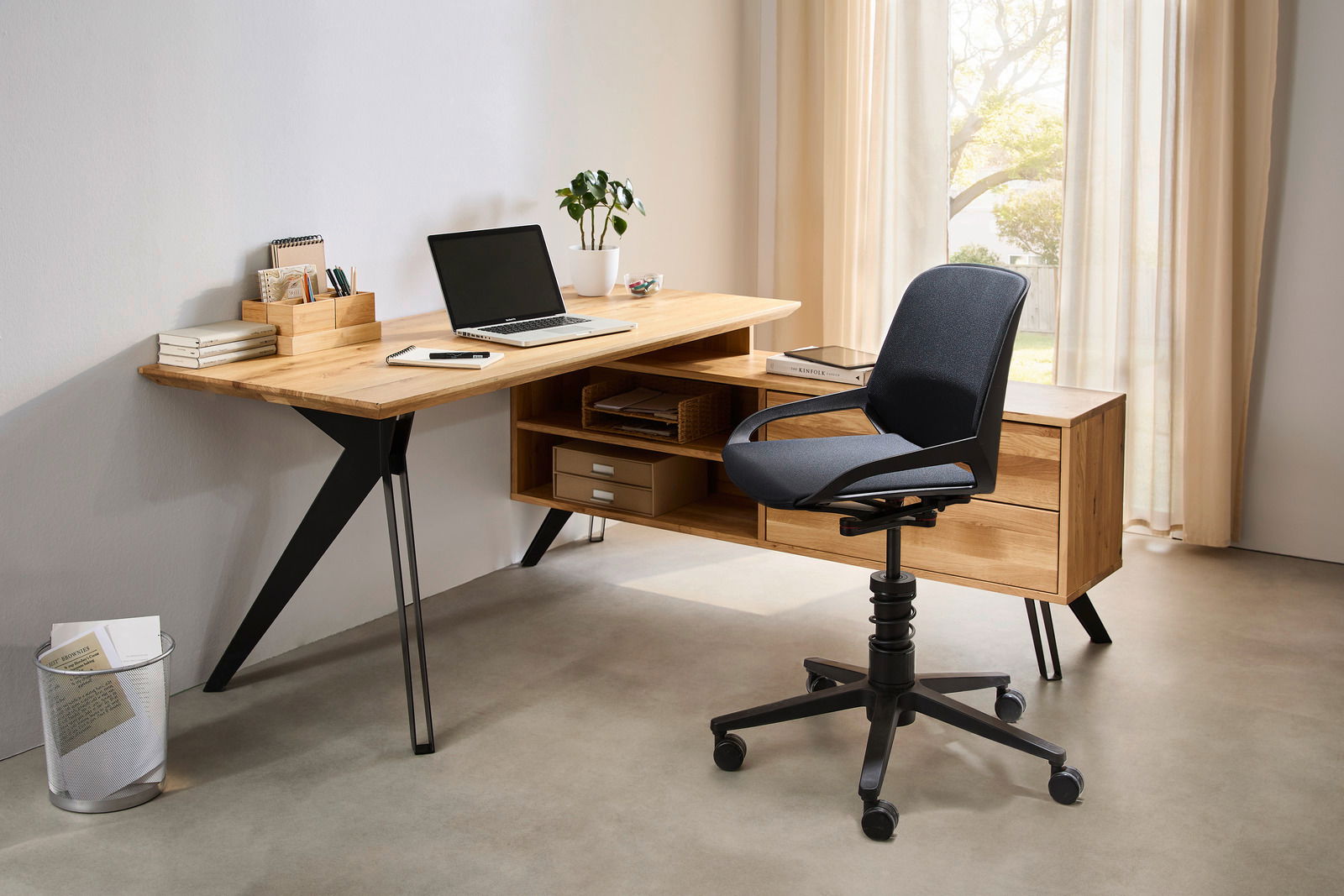 Moderner Eck-Schreibtisch aus Holz mit schwarzem Metallgestell, ausgestattet mit Regalfächern und Schubladen, seitliche Perspektive.