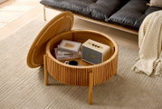 Runder Couchtisch aus Holz mit aufklappbarer Tischplatte, die Stauraum für Bücher und Lautsprecher bietet. Perspektive von oben.