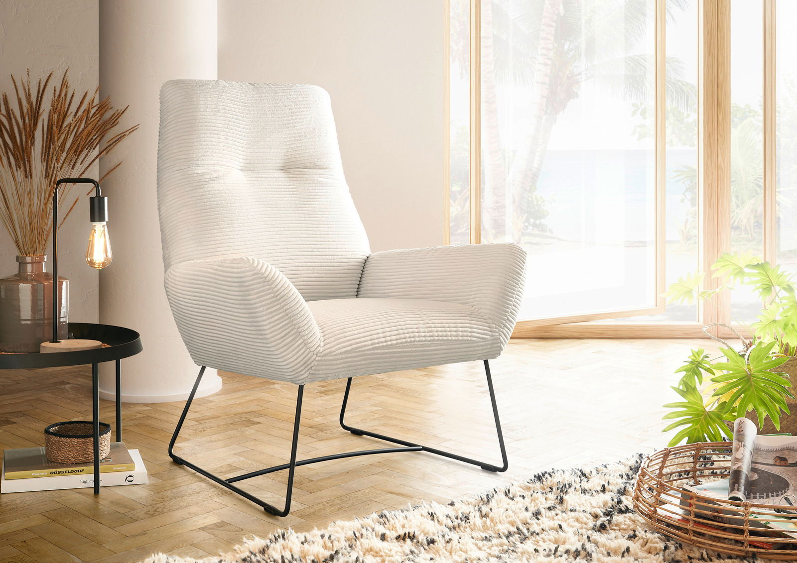 Lounge Handmade Sessel LH-BEN Moderner cremefarbener Sessel mit geripptem Stoffbezug und schwarzen Metallbeinen, seitliche Perspektive in einem hellen Raum mit großen Fenstern.