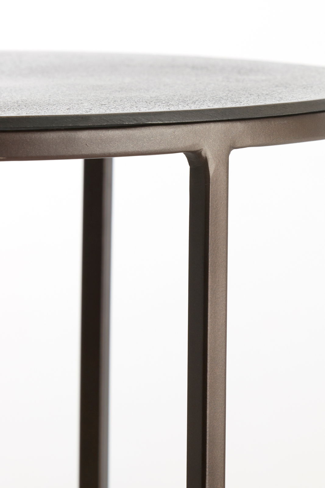 Nahaufnahme eines Beistelltisches mit runder Tischplatte und schlanken Metallbeinen, seitliche Perspektive.