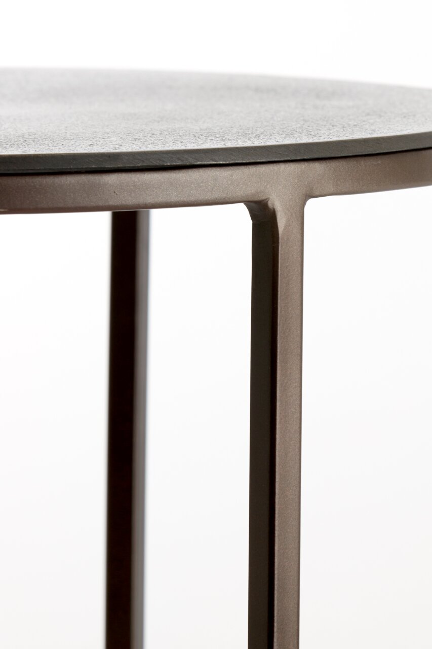 Nahaufnahme eines Beistelltisches mit runder Tischplatte und schlanken Metallbeinen, seitliche Perspektive.