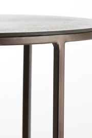 Nahaufnahme eines Beistelltisches mit runder Tischplatte und schlanken Metallbeinen, seitliche Perspektive.