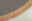 Nahaufnahme eines runden Teppichs mit Fransen, graue Textur und beige Fransen, von oben betrachtet.