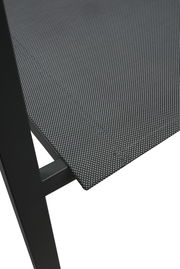 Nahaufnahme eines Stapelstuhls mit schwarzem Metallrahmen und grauem, texturiertem Sitzbezug, seitliche Perspektive