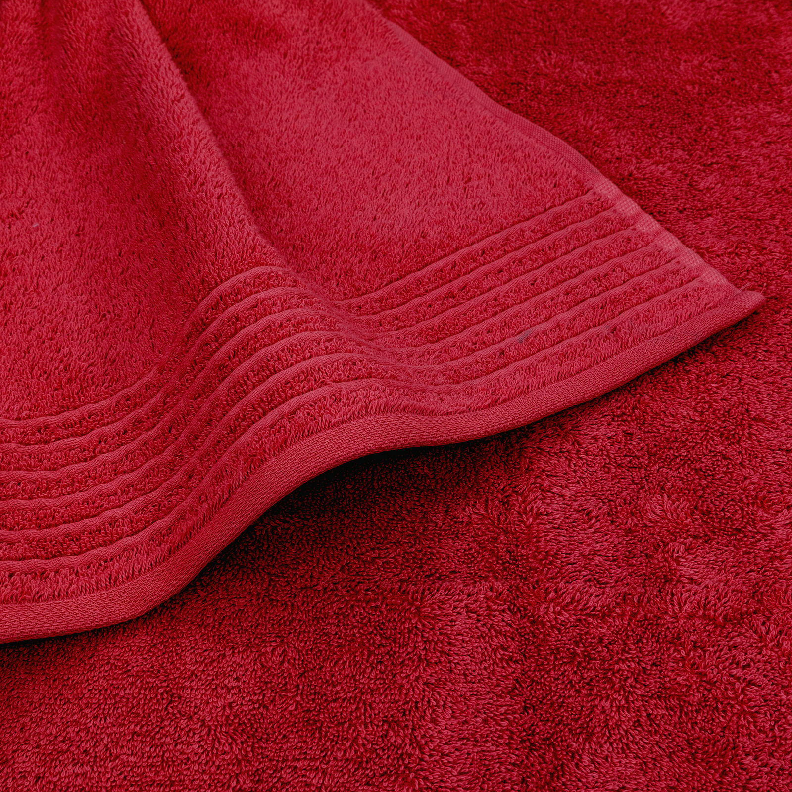 Rotes Handtuchset in Nahaufnahme, zeigt die Textur und das Design der Handtücher aus der Vogelperspektive.